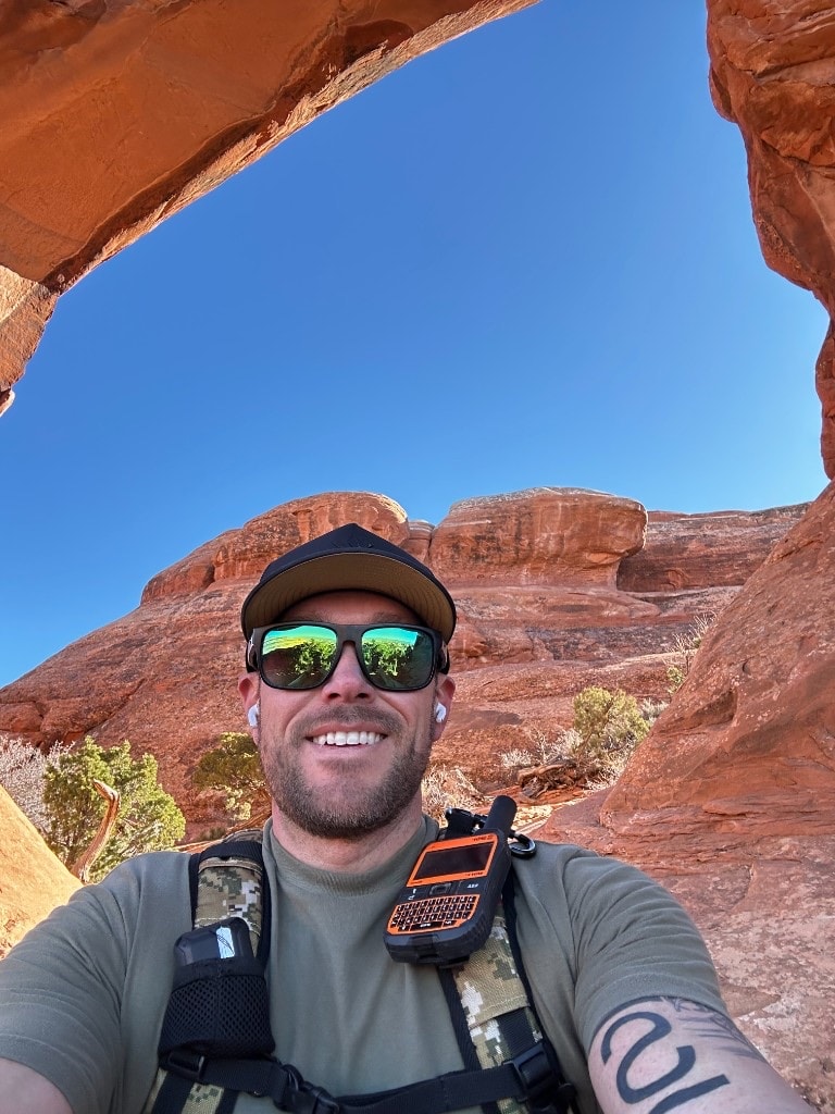Nick smiling beneath a red-rock desert arch