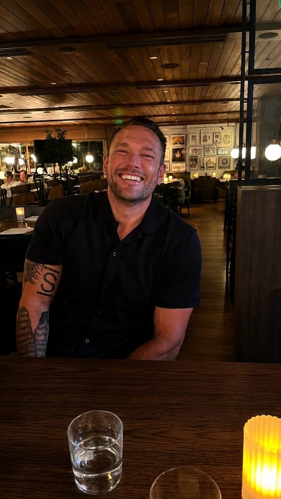 Nick smiling across a restaurant table during a conversation